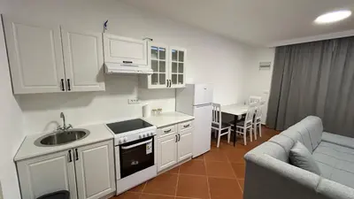 a kitchen with white cabinets and a sink at Stanovi VR in Bar