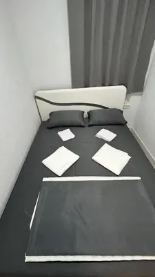 a bed with black sheets and pillows on it at Stanovi VR in Bar