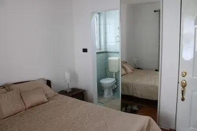 a bedroom with a bed and a bathroom with a toilet at Apartment Lux in Bar