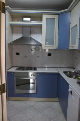 a blue kitchen with a stove and a sink at Apartment Lux in Bar