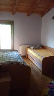 a bedroom with two beds and a window at Mlatkovina in Gluhi Do
