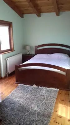 a bedroom with a large wooden bed with a rug at Mlatkovina in Gluhi Do