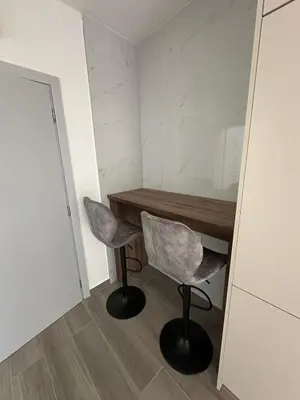a small room with a wooden table and two chairs at Apartman Aki 2 in Bar
