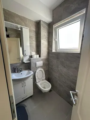 a bathroom with a toilet and a sink and a window at Apartman Aki 2 in Bar