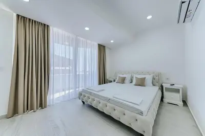 a white bedroom with a large bed and a window at Villa Blue Haven in Ulcinj