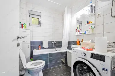 a white bathroom with a washing machine in it at Sunset in Kotor