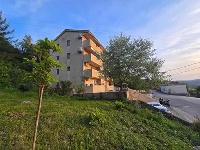 a building on the side of a hill with a tree at Sunset in Kotor