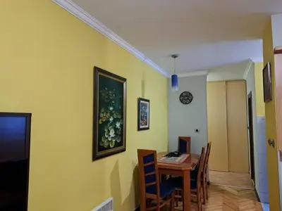 a dining room with a table and chairs and yellow walls at Holiday 2 in Kotor