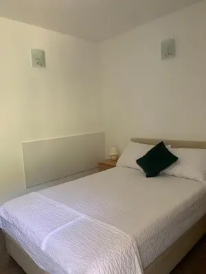 a bedroom with a white bed with a green pillow at Čanj apartmani in Čanj