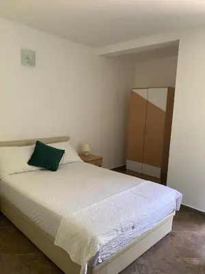 a bedroom with a bed with a green pillow at Čanj apartmani in Čanj