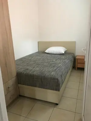 a bedroom with a bed with a white pillow on it at Čanj apartmani in Čanj
