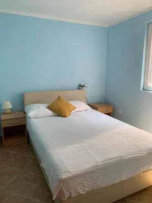a bedroom with a bed with two night stands and a window at Čanj apartmani in Čanj