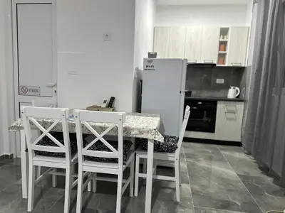 a kitchen with a table and chairs and a refrigerator at Apartman 2 in Bar, Susanj