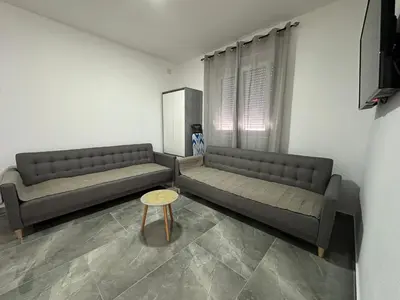 a living room with two couches and a table at Apartman 2 in Bar, Susanj