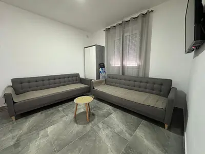 a living room with two couches and a table at Apartman 2 in Bar, Susanj