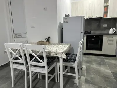 a kitchen with a table and chairs and a refrigerator at Apartman 2 in Bar, Susanj