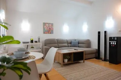 a living room with a couch and a table at Airport Apartments Una in Mitrovići