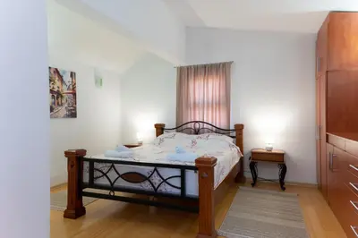 a bedroom with a bed and a window at Airport Apartments Una in Mitrovići