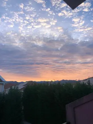 a cloudy sky at sunset with mountains in the background at Airport Apartments Una in Mitrovići