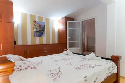 a bedroom with a large bed with flowers on it at Airport Apartments Una in Mitrovići