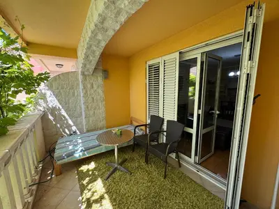 a balcony with a table and chairs and a glass door at Comfortable family apartments in Przno in Pržno