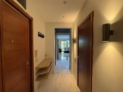 a hallway with a wooden door and a wooden bench at Comfortable family apartments in Przno in Pržno