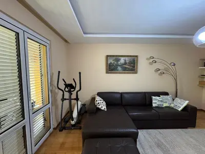 a living room with a black couch and a window at Comfortable family apartments in Przno in Pržno