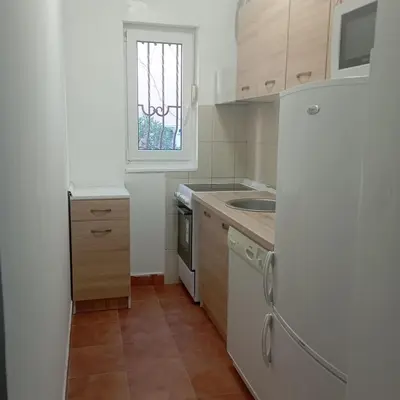 a kitchen with a refrigerator and a sink and a window at Nice summer apartment near sea in Budva