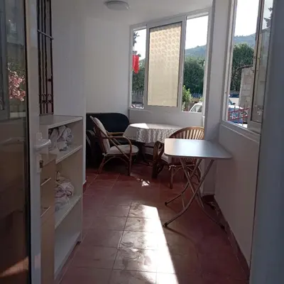 a room with a table and chairs and windows at Nice summer apartment near sea in Budva