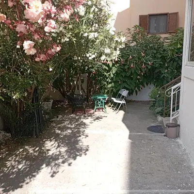 a garden with roses and a table and chairs at Nice summer apartment near sea in Budva