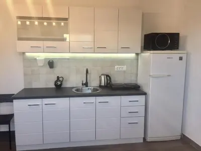 a white kitchen with a sink and a refrigerator at Aparthotel Monterria in Bar