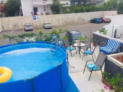 a swimming pool with chairs and a table in a parking lot at Aparthotel Monterria in Bar