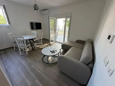 a living room with a couch and a table at Apartmani Aki 3 in Sutomore