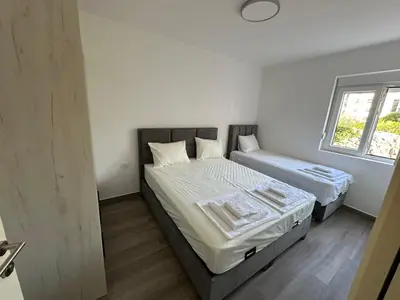 a bedroom with two beds and a window at Apartmani Aki 3 in Sutomore