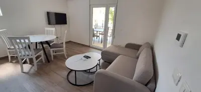 a living room with a couch and a table at Apartmani Aki 3 in Sutomore