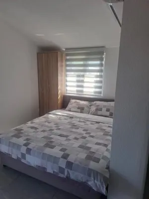 a bedroom with a large bed with a checkered blanket at Apartman Andjela 1 in Budva