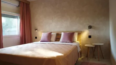 a bedroom with a bed with pink pillows and a window at Jelena Lapčići Budva in Budva
