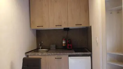 a small kitchen with a sink and wooden cabinets at Jelena Lapčići Budva in Budva