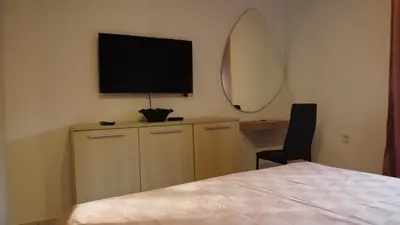 a bedroom with a bed and a television on the wall at Jelena Lapčići Budva in Budva