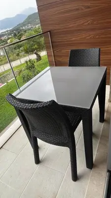 a white table and a chair on a balcony at Casa Montenegro 1 Plus 1 Suite View Sea and Pool in Kavač