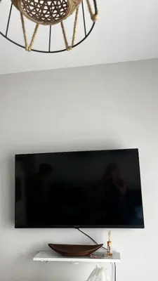a flat screen tv hanging on a white wall at Casa Montenegro 1 Plus 1 Suite View Sea and Pool in Kavač