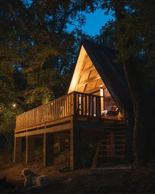 a tree house with a dog laying in front of it at Oak Cabin in Ulcinj