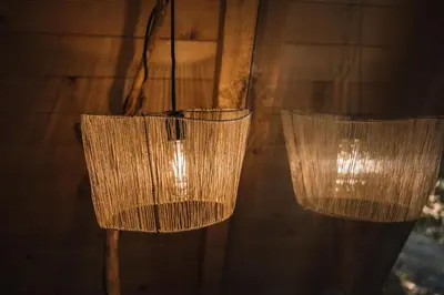 two chandeliers hanging from a wooden wall at Oak Cabin in Ulcinj