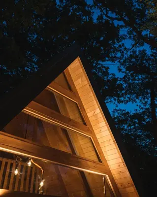 a building with glass windows at night at Oak Cabin in Ulcinj