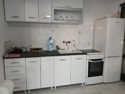 a white kitchen with a sink and a refrigerator at MonaLiza in Ulcinj