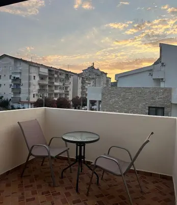 a balcony with two chairs and a table on a roof at Apartmani Rira in Sutomore