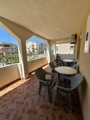 a room with tables and chairs and windows at Apartmani Rira in Sutomore
