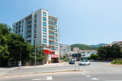 a city street with a building and cars on the road at Lovely onebedroom Becici in Becici