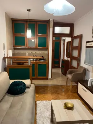 a living room with a couch and a kitchen at Apartman Kutak in Bar