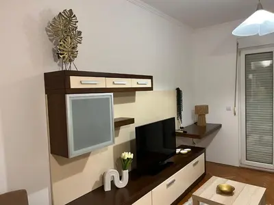 a living room with a flat screen tv on a wall at Apartman Kutak in Bar